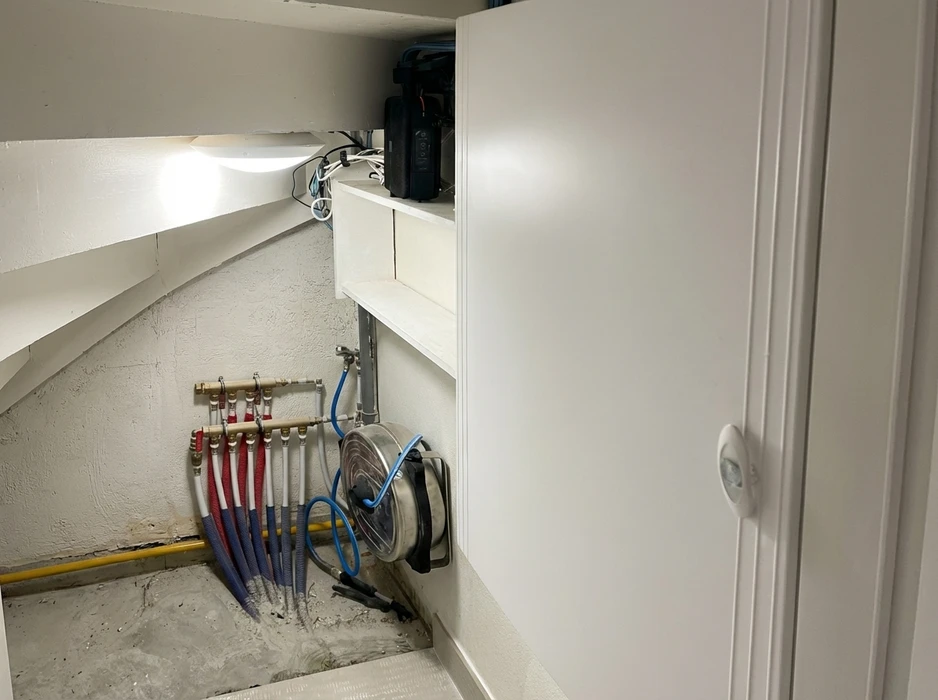 Placard technique sous escalier, murs blancs